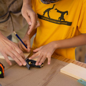 child and adult working together on woodworking