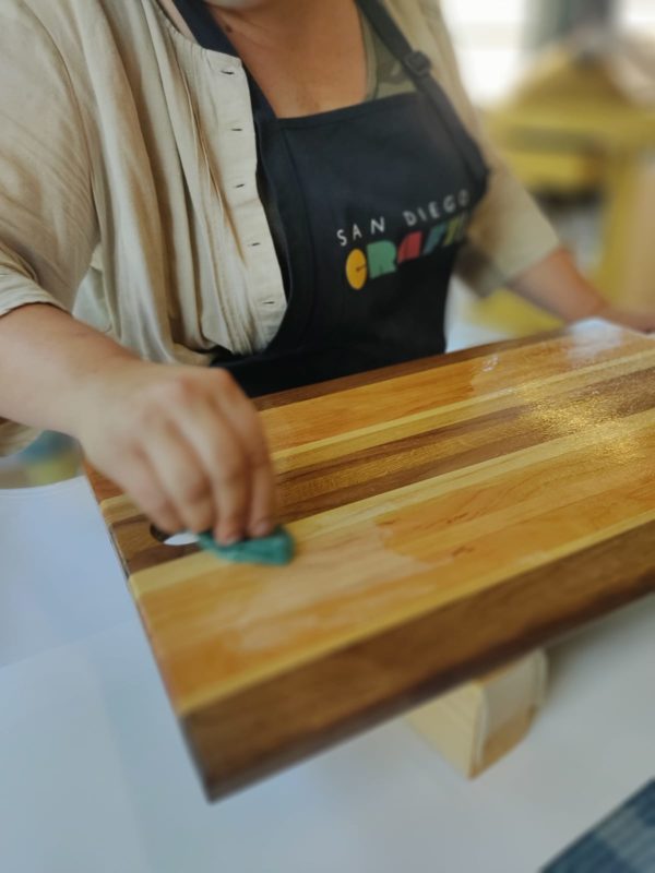 Woman applying finish to cutting board
