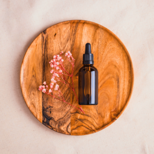 bottle of perfume on a wooden board with flower