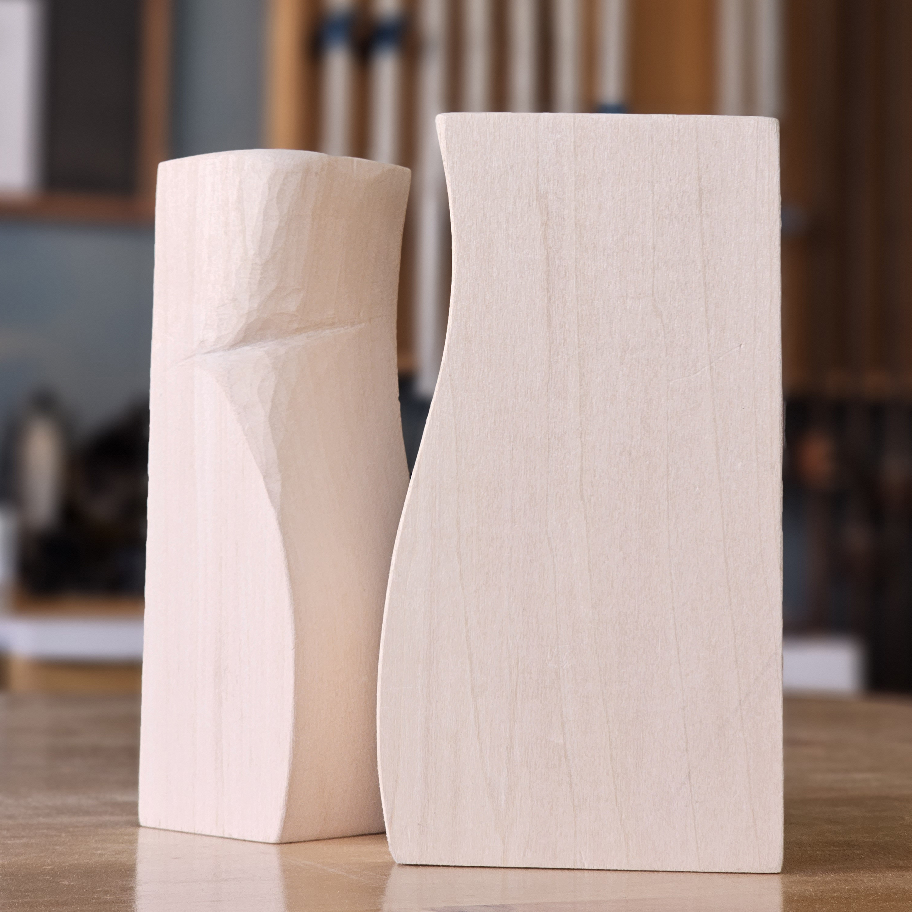 two shaped wood pieces sitting on the work bench in the woodshop