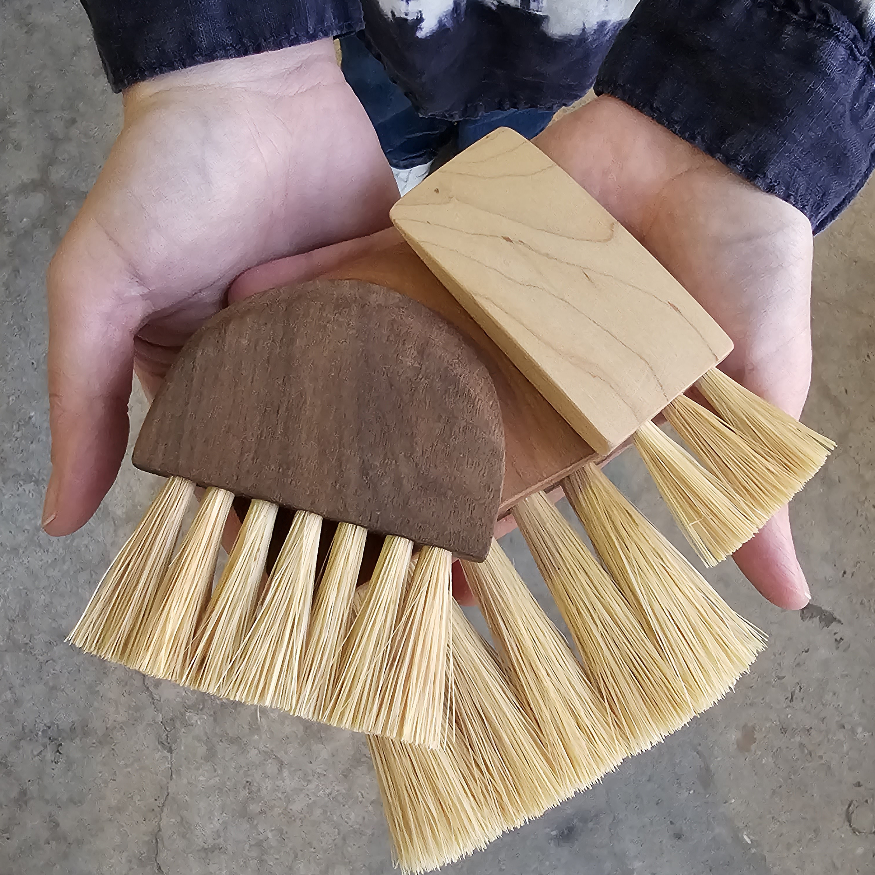 hands holding 3 handmade wooden handled artisan brushes
