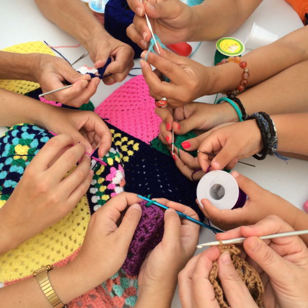 hands with yarn and crochet hooks crafting