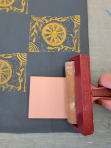 close-up of hand and roller block printing on blue fabric