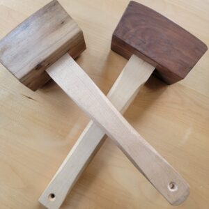 pic of two carpenter's mallets laying on table in an X