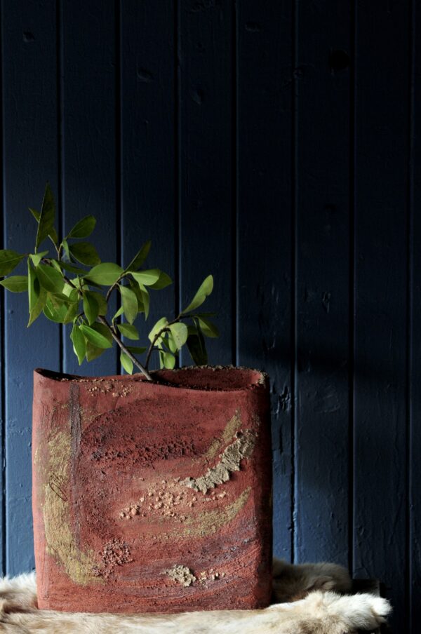 handmade ceramic pot on table with dark black wall background
