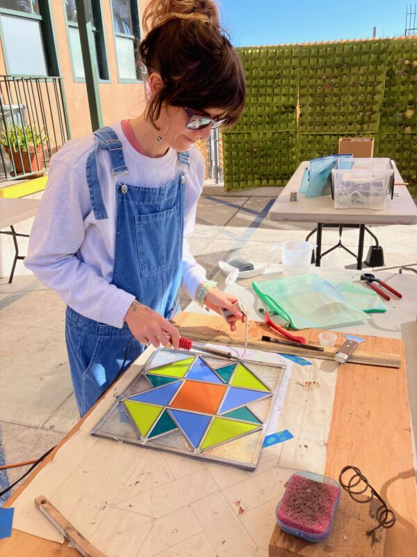 student working on a leaded stained glass piece