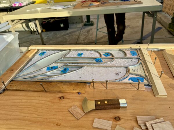 stained glass piece resting on table being built