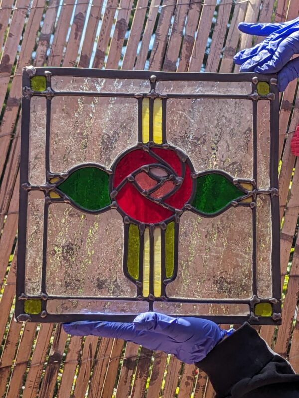 two hands holding a leaded stained glass piece