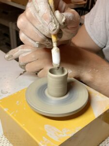 hands at work on a tiny miniature clay wheel