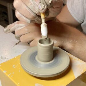 hands at work on a tiny miniature clay wheel