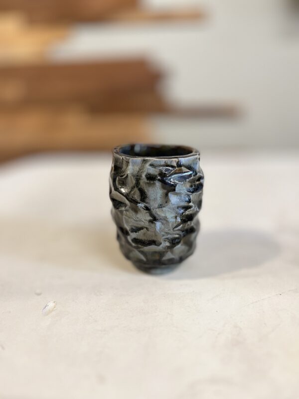 close up of one small kurinuki clay tea cup on a table