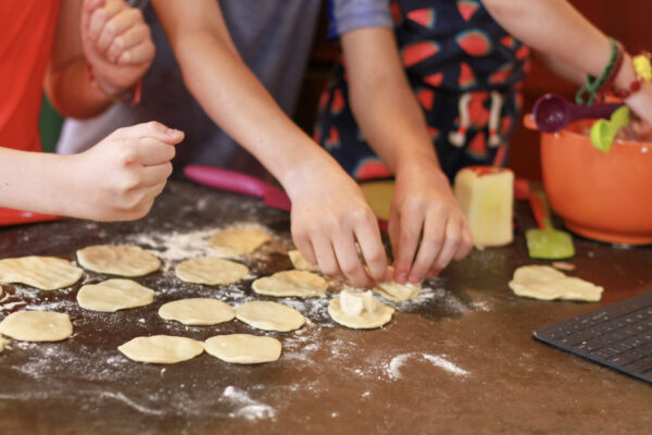 kids hands rolling dumplings