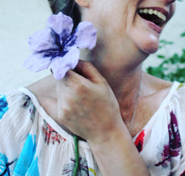 woman holding wet felted purple flower