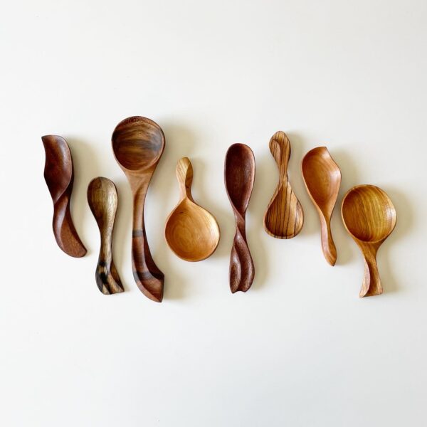 close up of a set of golden colored wooden power carved spoons