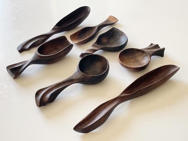 close up of a set of dark colored wooden power carved spoons