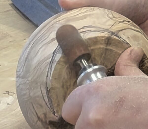 power carving tool working on bottom of bowl