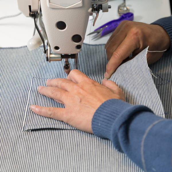 person sewing an apron on a sewing machine