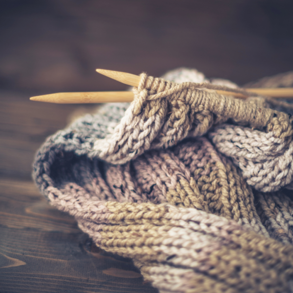 brown knit fabric close-up with knitting needles in progress