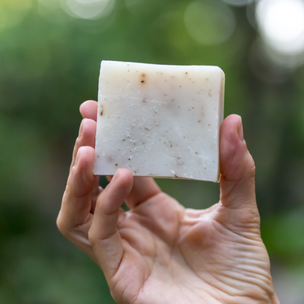 hand holding soap with green background