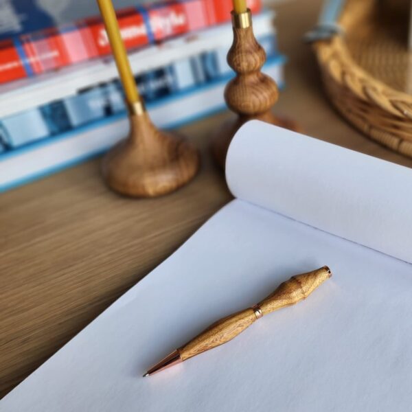 wooden pen laying on pad of paper