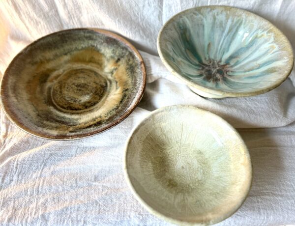 three glazed bowls thrown on a pottery wheel