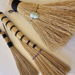 close up of three handmade hand brooms