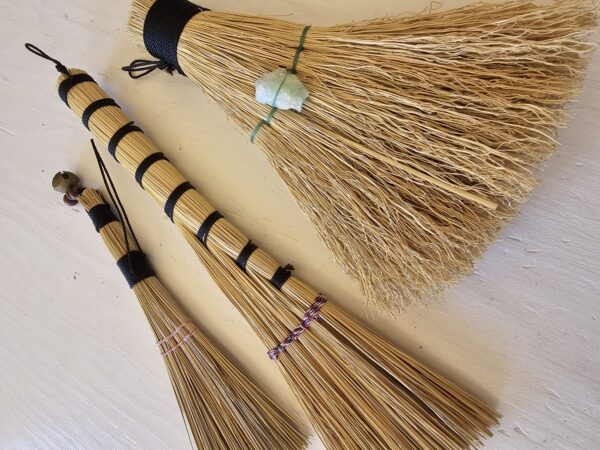 close up of three handmade hand brooms