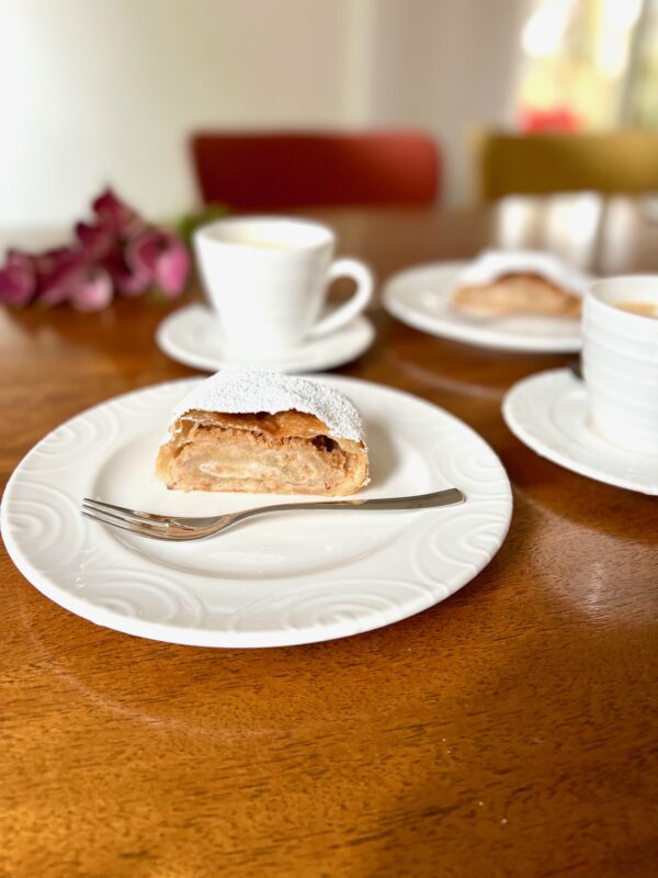 Austrian Strudel on a plate with coffee in the background