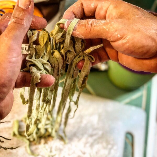 hands holding fresh pasta noodles