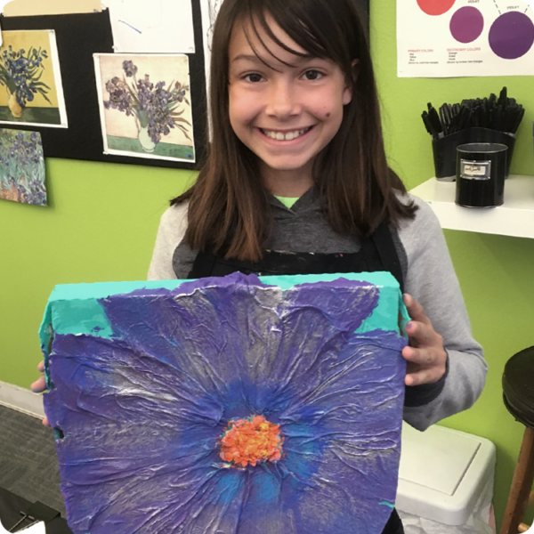 child holding painting of flower