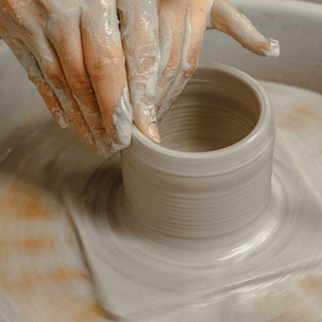 hands working with clay throwing pottery