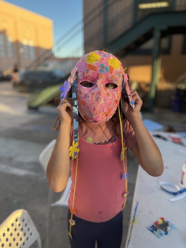 child wearing handmade paper mache mask