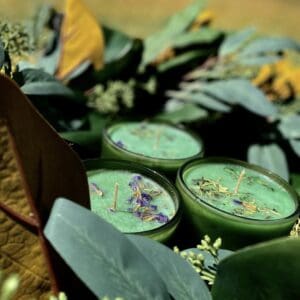 green candles with leaves around them