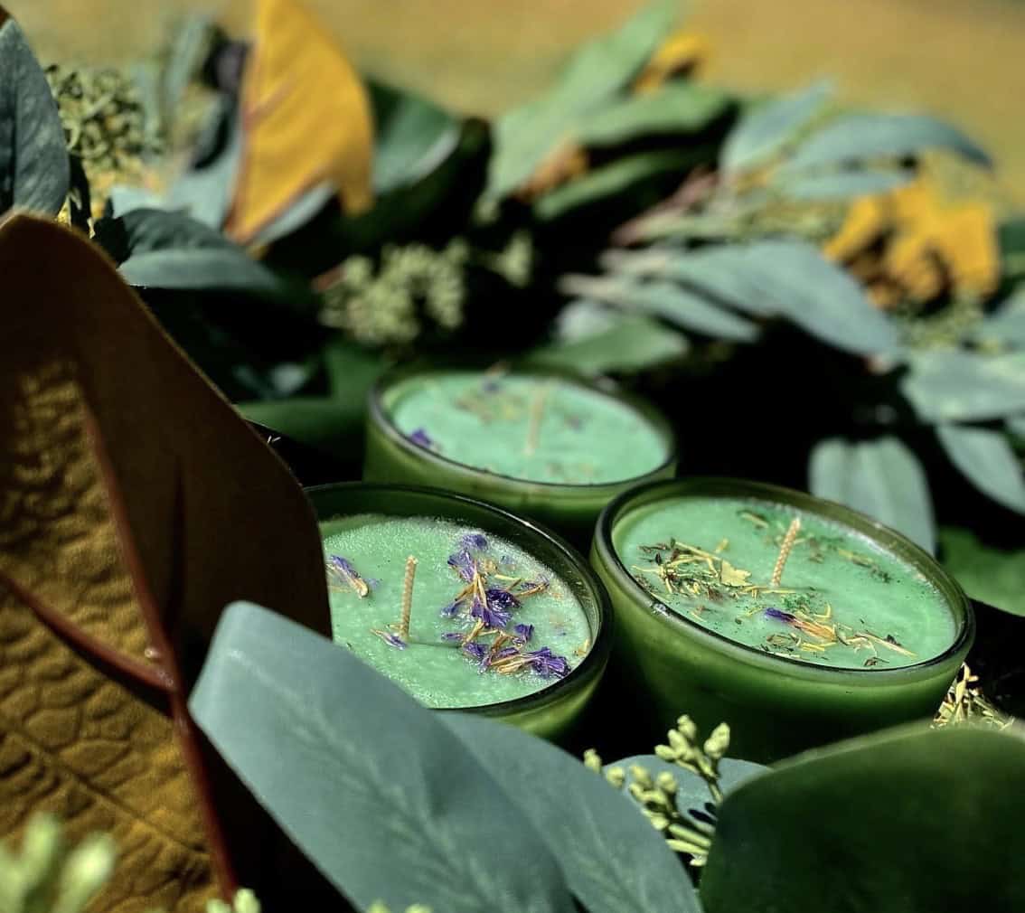 green candles with leaves around them