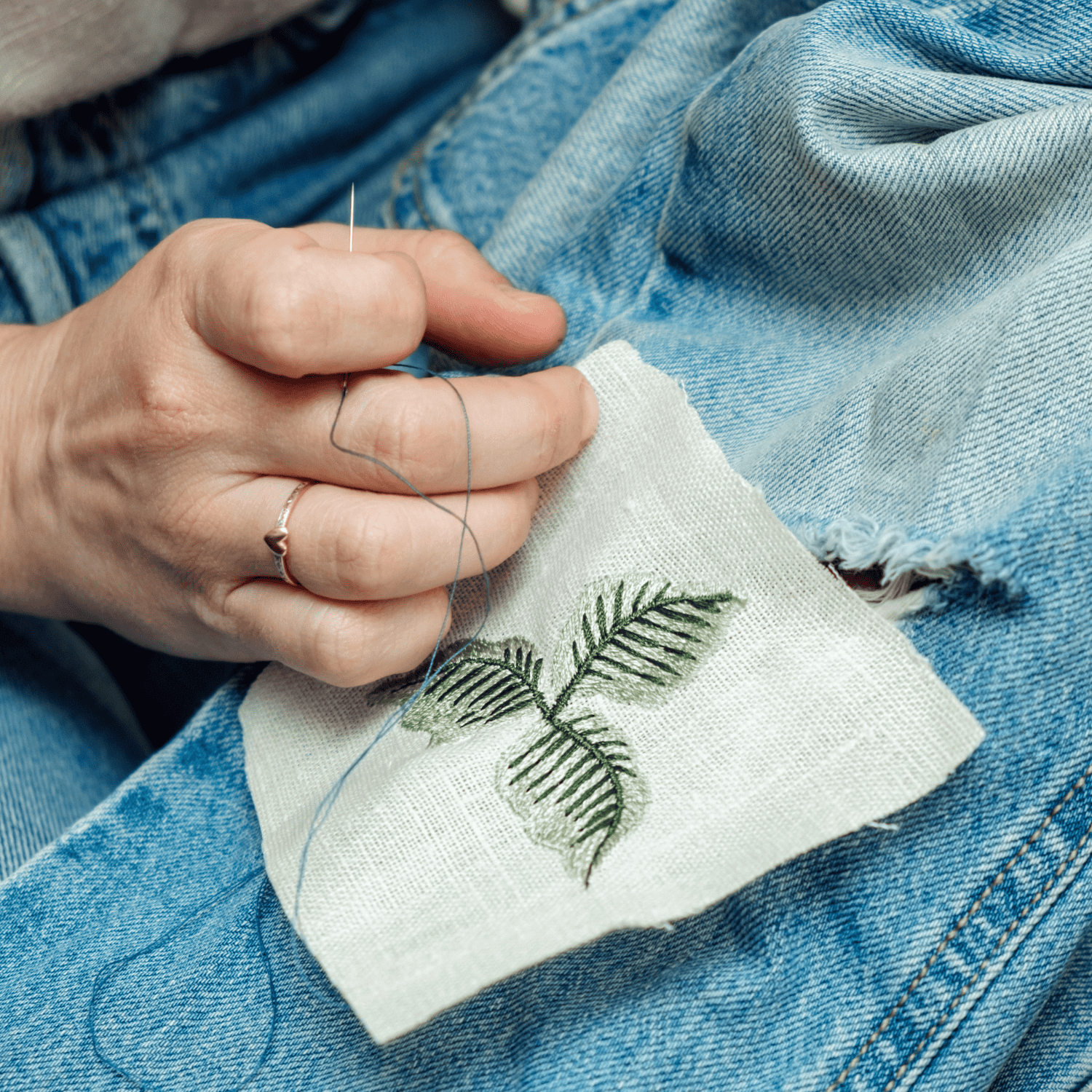 hand mending hold in fabric with design